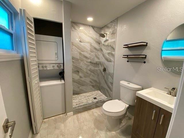 1829 10th St N, Saint Petersburg, FL 33704 - bathroom featuring vanity, stacked washer / drying machine, toilet, and tiled shower