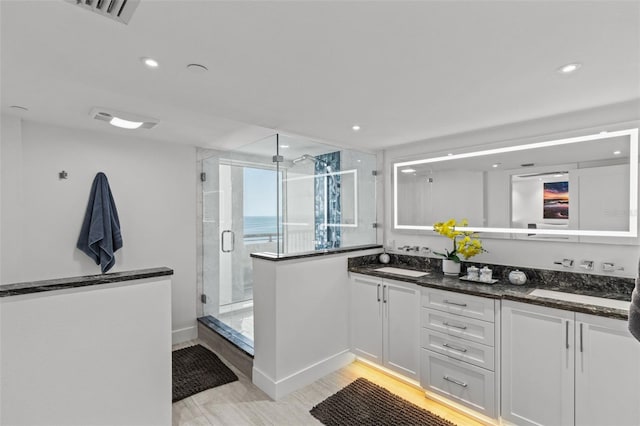 kitchen with white cabinetry, sink, and dark stone counters