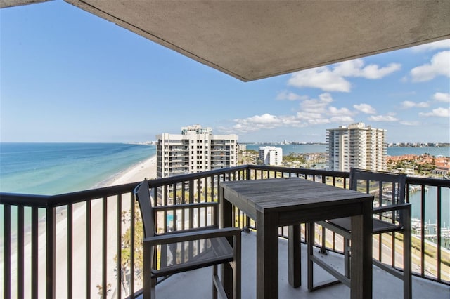 balcony featuring a water view and a beach view