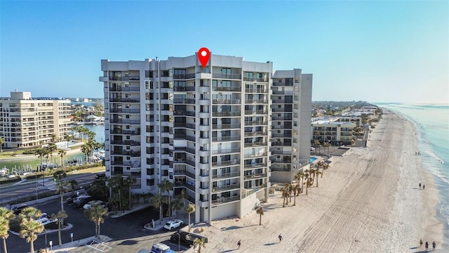 view of building exterior with a water view and a beach view