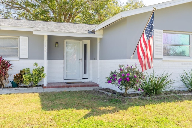 view of exterior entry featuring a yard