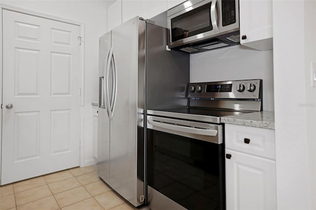 kitchen with stainless steel appliances, light stone countertops, light tile patterned floors, and white cabinets