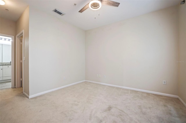 empty room featuring light colored carpet and ceiling fan