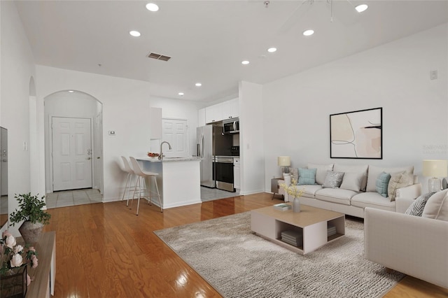 living room with sink and light hardwood / wood-style floors