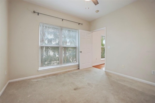 unfurnished room with light colored carpet and ceiling fan