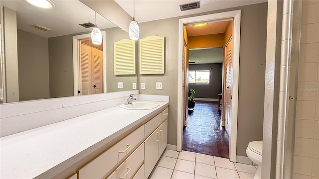 bathroom with tile patterned flooring, vanity, and toilet