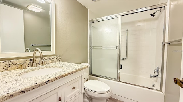 full bathroom featuring enclosed tub / shower combo, vanity, and toilet