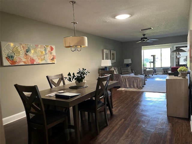 dining area with dark wood-type flooring, ceiling fan, lofted ceiling, and a textured ceiling