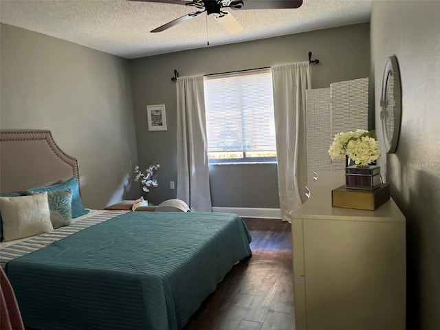 bedroom with ceiling fan, dark hardwood / wood-style floors, and a textured ceiling