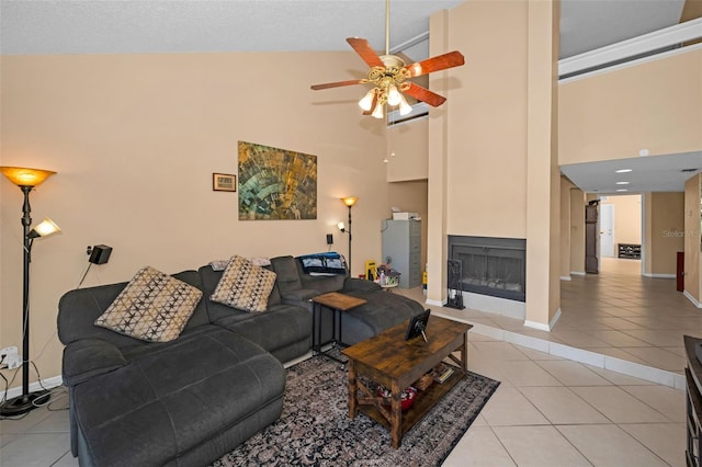 tiled living room featuring ceiling fan and a high ceiling