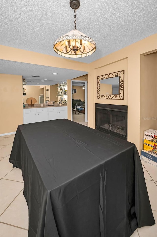 playroom with a textured ceiling and light tile patterned flooring