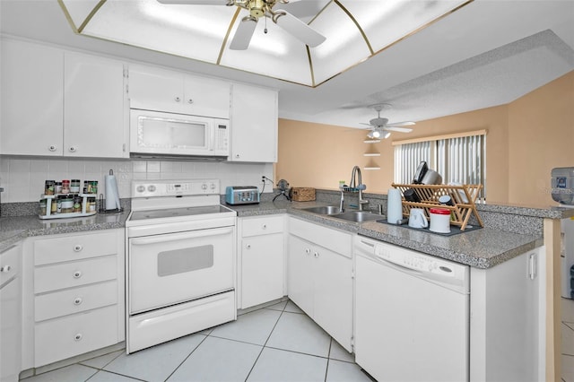 kitchen featuring sink, white appliances, white cabinetry, light tile patterned flooring, and kitchen peninsula