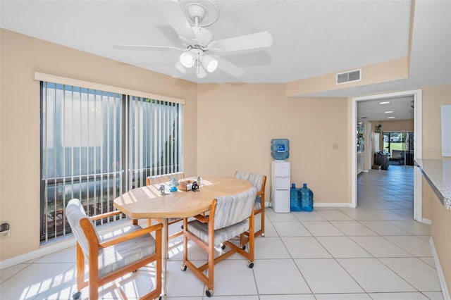 tiled dining room featuring a textured ceiling and ceiling fan