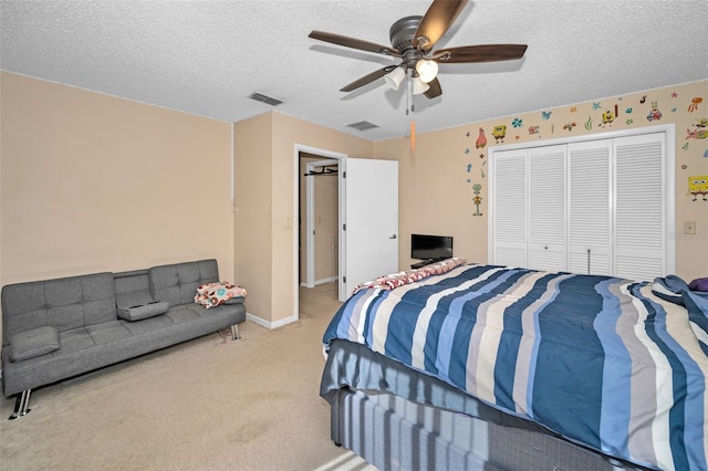 bedroom featuring light carpet, ceiling fan, a closet, and a textured ceiling