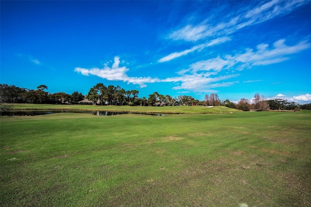 surrounding community with a yard and a water view