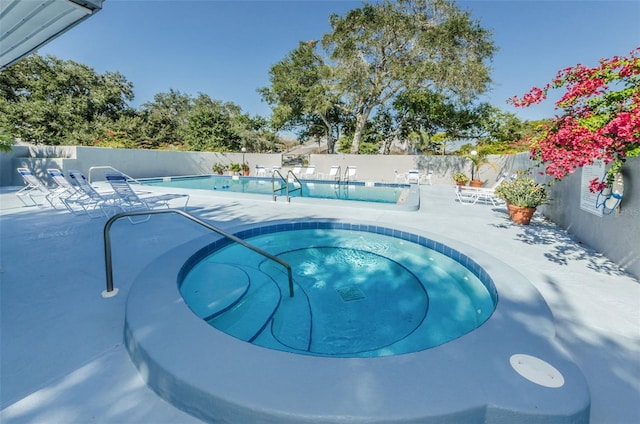 view of swimming pool with a hot tub and a patio