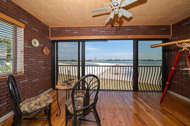 sunroom with a water view, wooden ceiling, and ceiling fan