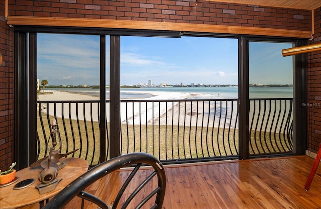 sunroom / solarium with a water view and a beach view