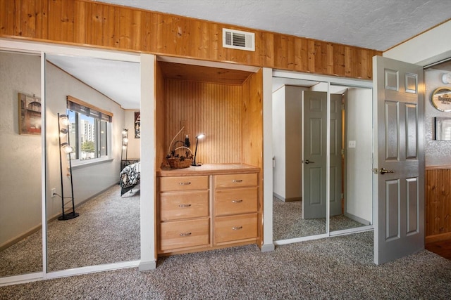 interior space with wooden walls and a textured ceiling