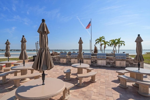 view of patio featuring a water view, area for grilling, and grilling area