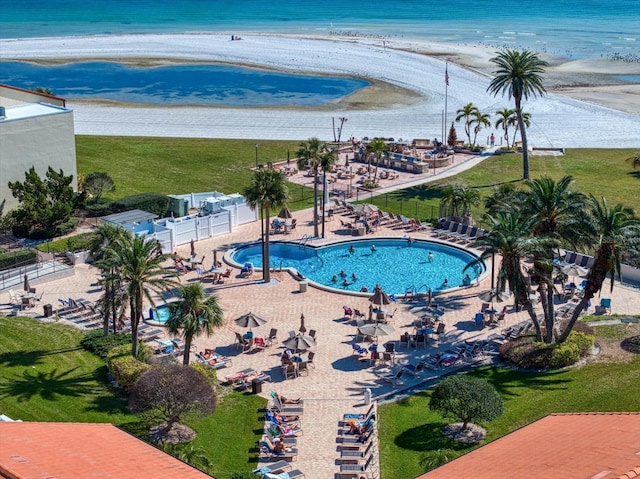 view of swimming pool with a water view and a view of the beach