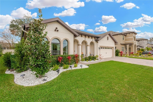 mediterranean / spanish-style house featuring stucco siding, a garage, concrete driveway, and a front yard