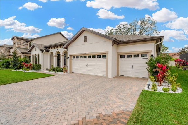 view of front of home with stucco siding, an attached garage, decorative driveway, and a front lawn