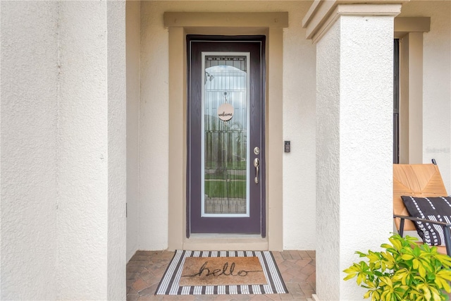 property entrance with stucco siding