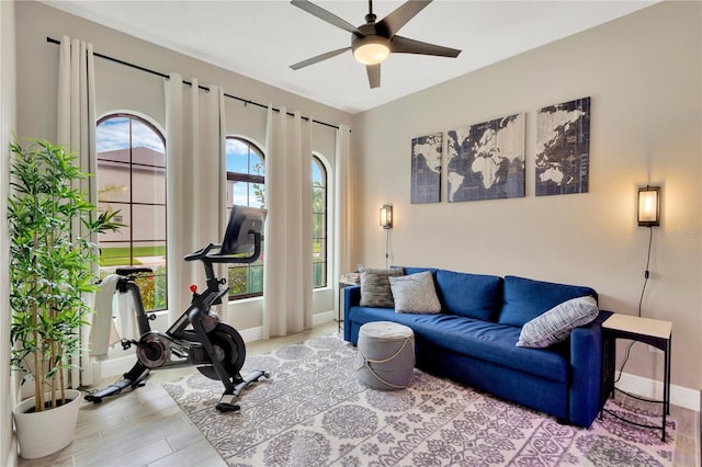 interior space with ceiling fan, baseboards, plenty of natural light, and wood finished floors