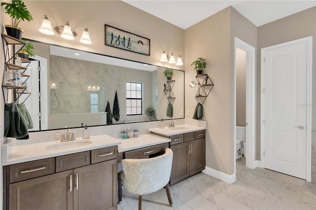 bathroom with vanity, marble finish floor, baseboards, toilet, and a walk in shower