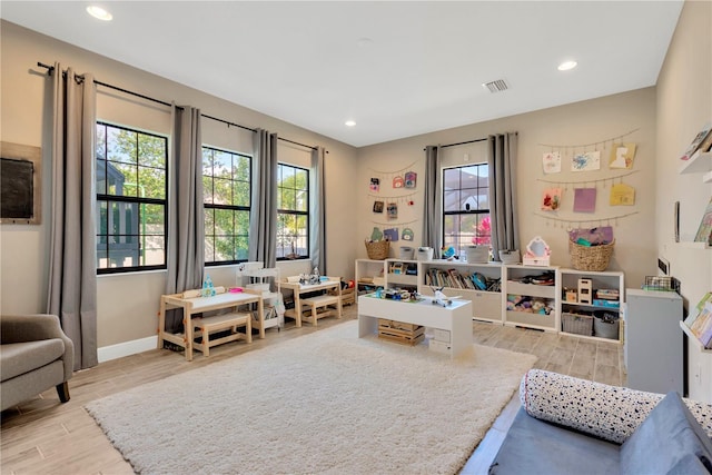 playroom with visible vents, a healthy amount of sunlight, and wood tiled floor