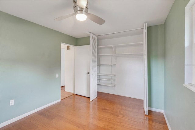 unfurnished bedroom with a closet, light wood-type flooring, a ceiling fan, and baseboards