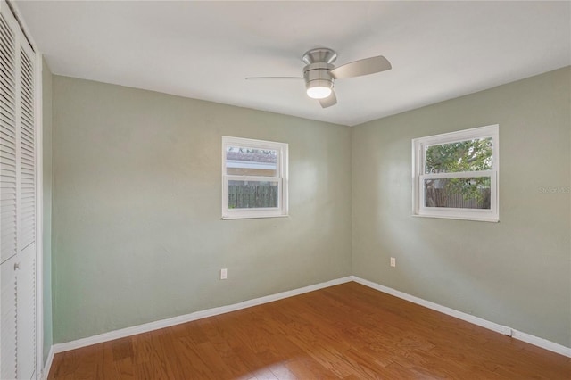 unfurnished bedroom featuring a closet, wood finished floors, and baseboards