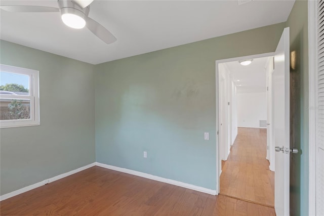 unfurnished room with ceiling fan, baseboards, and wood finished floors