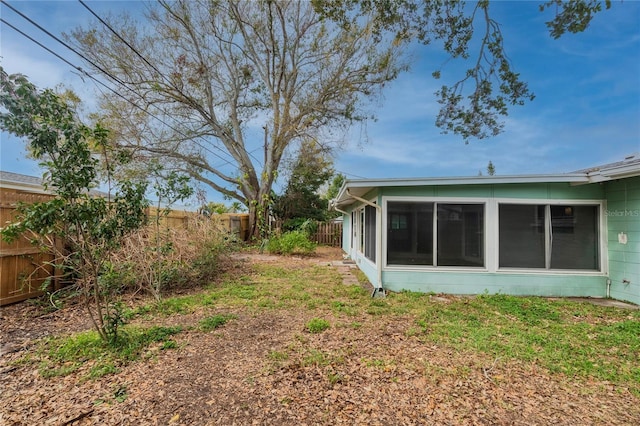 view of yard with a sunroom and a fenced backyard