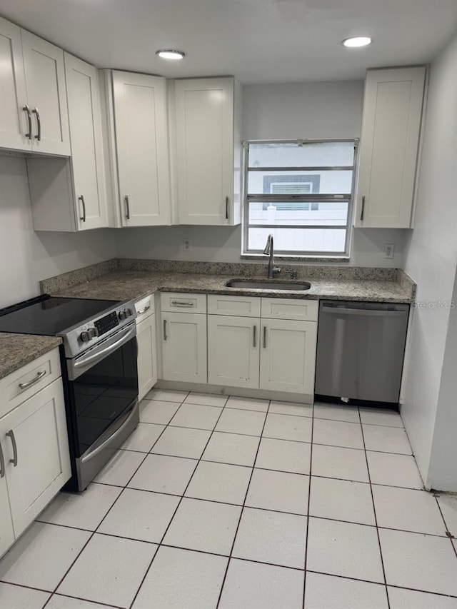 kitchen featuring light tile patterned floors, stainless steel appliances, sink, and white cabinets