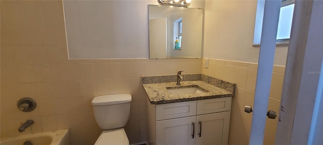 bathroom with tile walls, vanity, and toilet