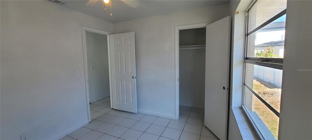 unfurnished bedroom with ceiling fan, a closet, and light tile patterned floors