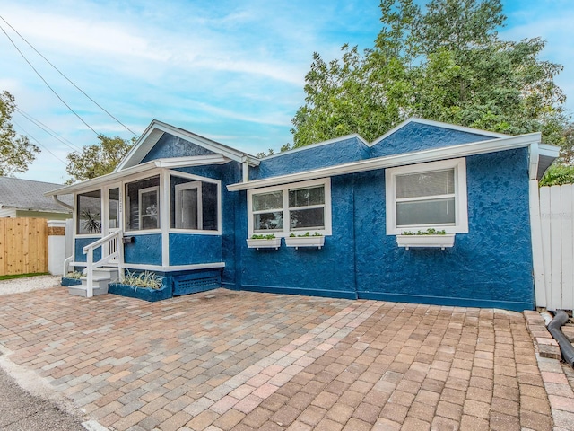 view of front of house with a patio area and a sunroom