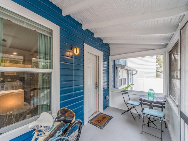 sunroom / solarium featuring beamed ceiling