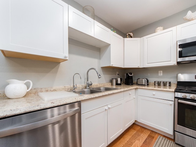 kitchen featuring sink, appliances with stainless steel finishes, and white cabinetry