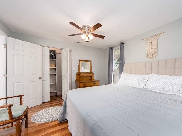 bedroom featuring a closet, a spacious closet, ceiling fan, and light hardwood / wood-style flooring