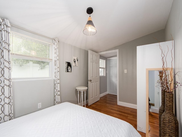 bedroom with hardwood / wood-style flooring and lofted ceiling