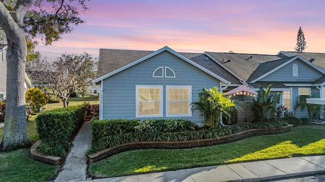 property exterior at dusk featuring a yard