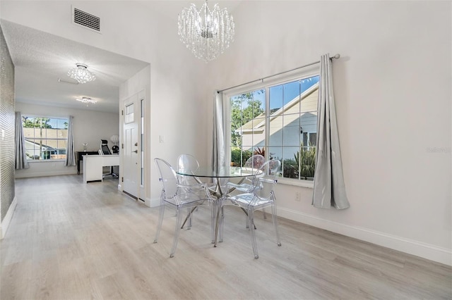 unfurnished dining area with a notable chandelier and light hardwood / wood-style floors