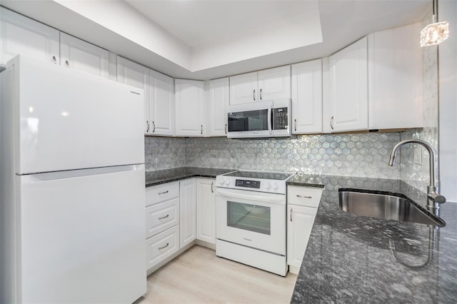 kitchen with white cabinetry, white appliances, sink, and pendant lighting