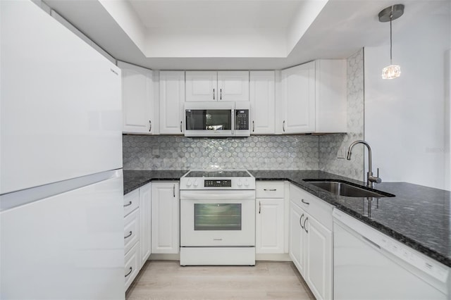 kitchen featuring sink, white cabinetry, light wood-type flooring, pendant lighting, and white appliances