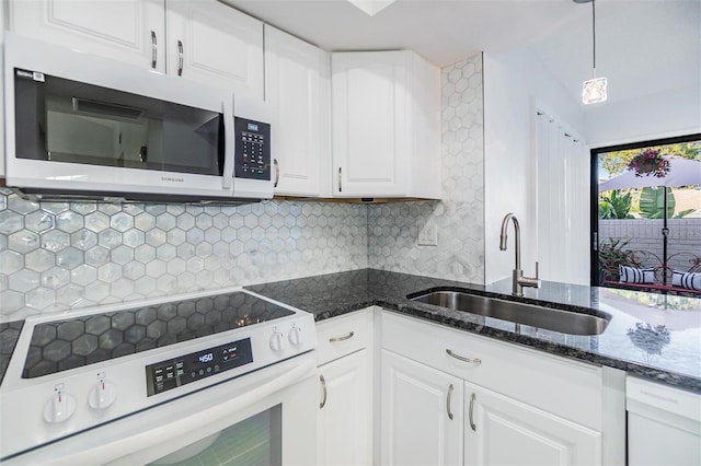 kitchen with sink, white cabinetry, backsplash, range with electric stovetop, and decorative light fixtures