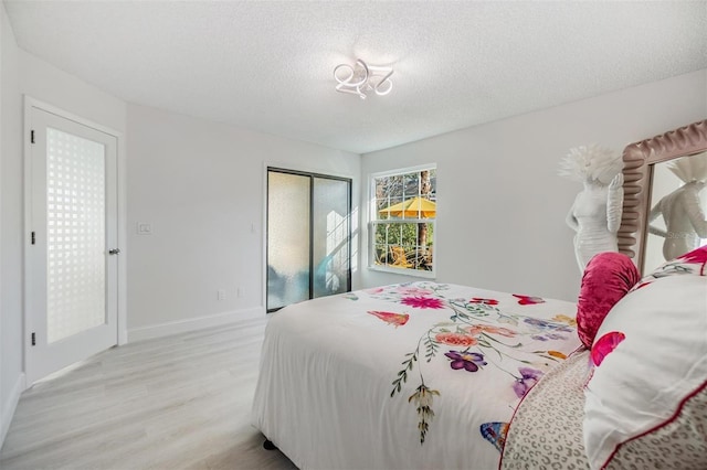 bedroom featuring a textured ceiling, light wood-type flooring, and a closet