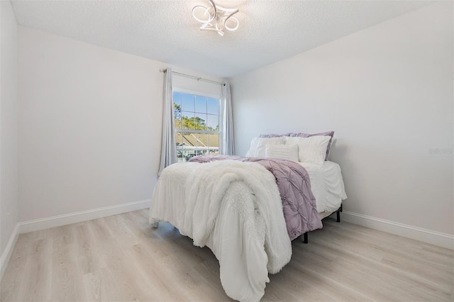 bedroom featuring light hardwood / wood-style flooring and a textured ceiling